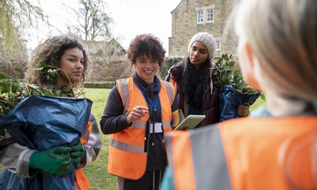 a group of people in high-vis jacket and gardening gloves