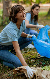 A team of corporate volunteering picking up rubbish from a park floor