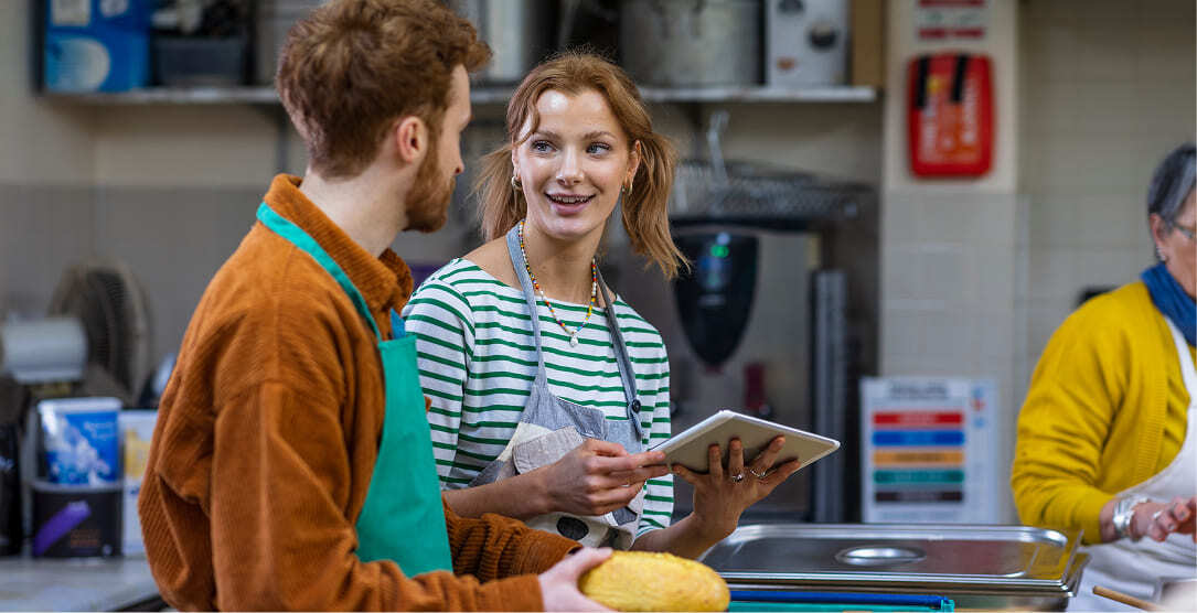 Two people volunteering in a kitchen